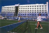 Two women playing tennis on board the floating hotel.