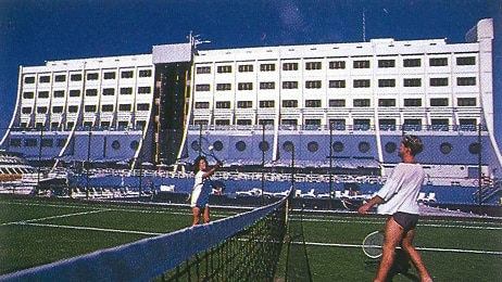 Two women playing tennis on board the floating hotel.
