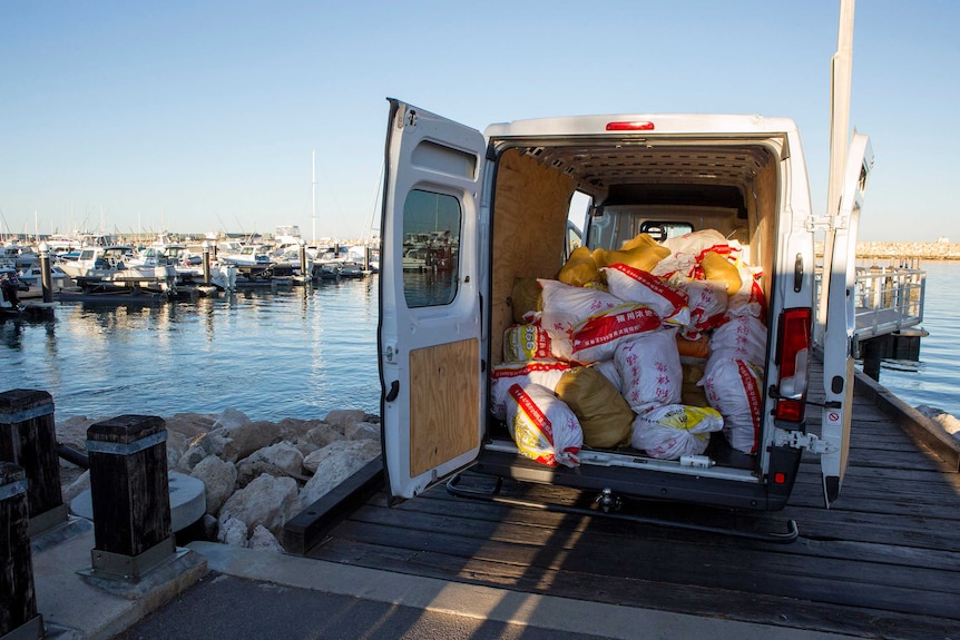 Микробус с отворени задни врати с товар от торби, съдържащи метамфетамин, на пристанище Джералдтън.