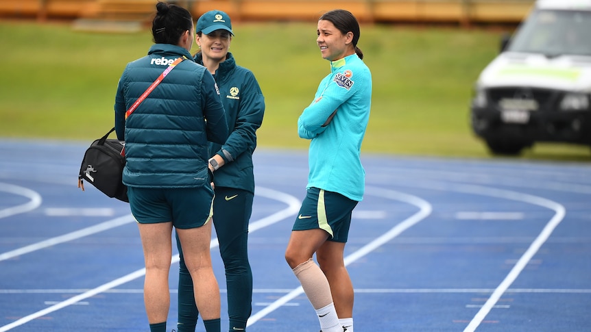 Sam Kerr chats to Matildas staff with her left calf bandaged at a Brisbane training session.