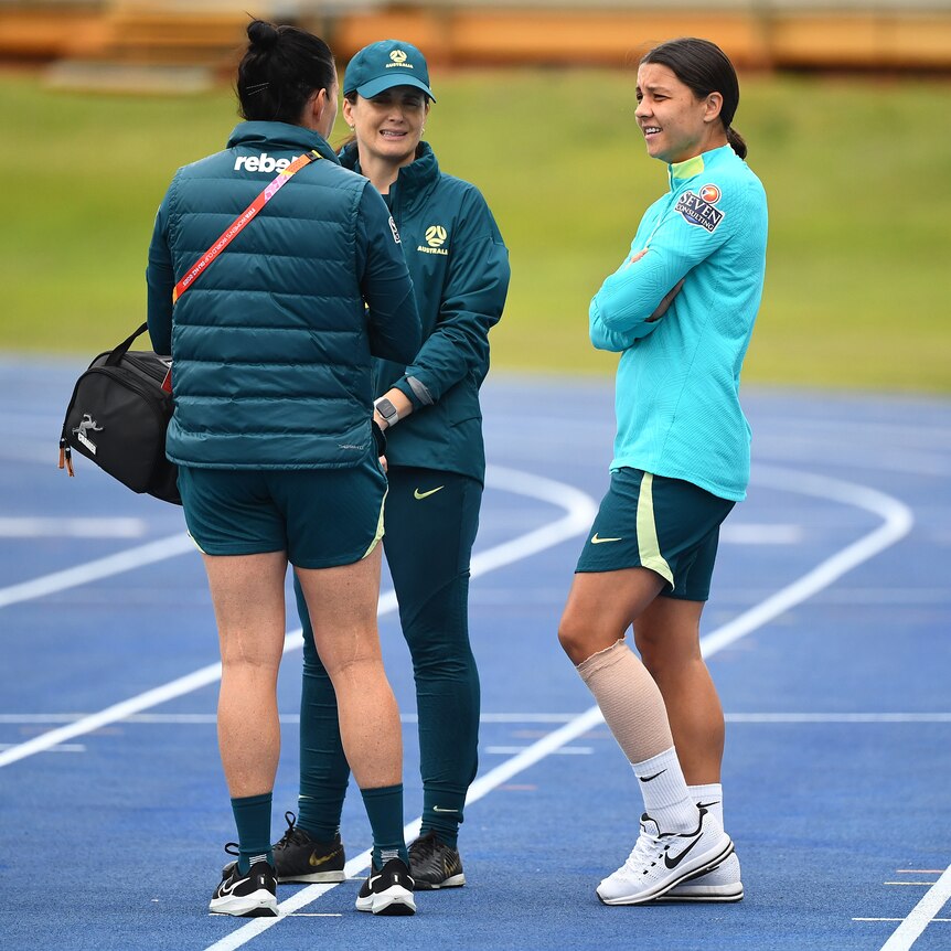Sam Kerr chats to Matildas staff with her left calf bandaged at a Brisbane training session.