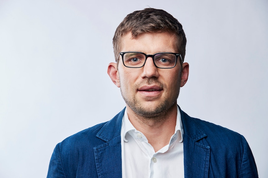 man in white shirt, blue jacket and glasses 