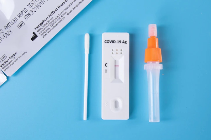 A COVID-19 rapid antigen test laying on a blue bench.