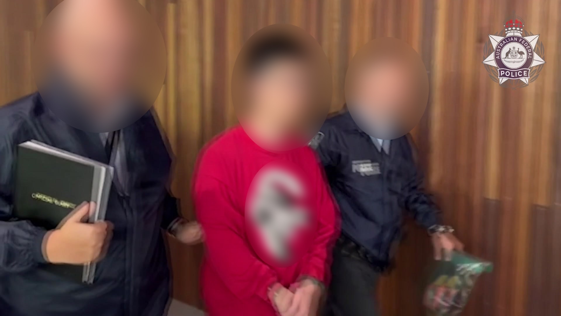 Um homem é preso, todos os rostos estão desfocados.