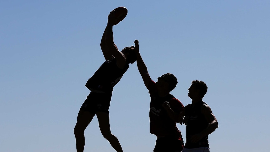 AFL players leap for ball