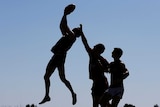 AFL players leap for ball