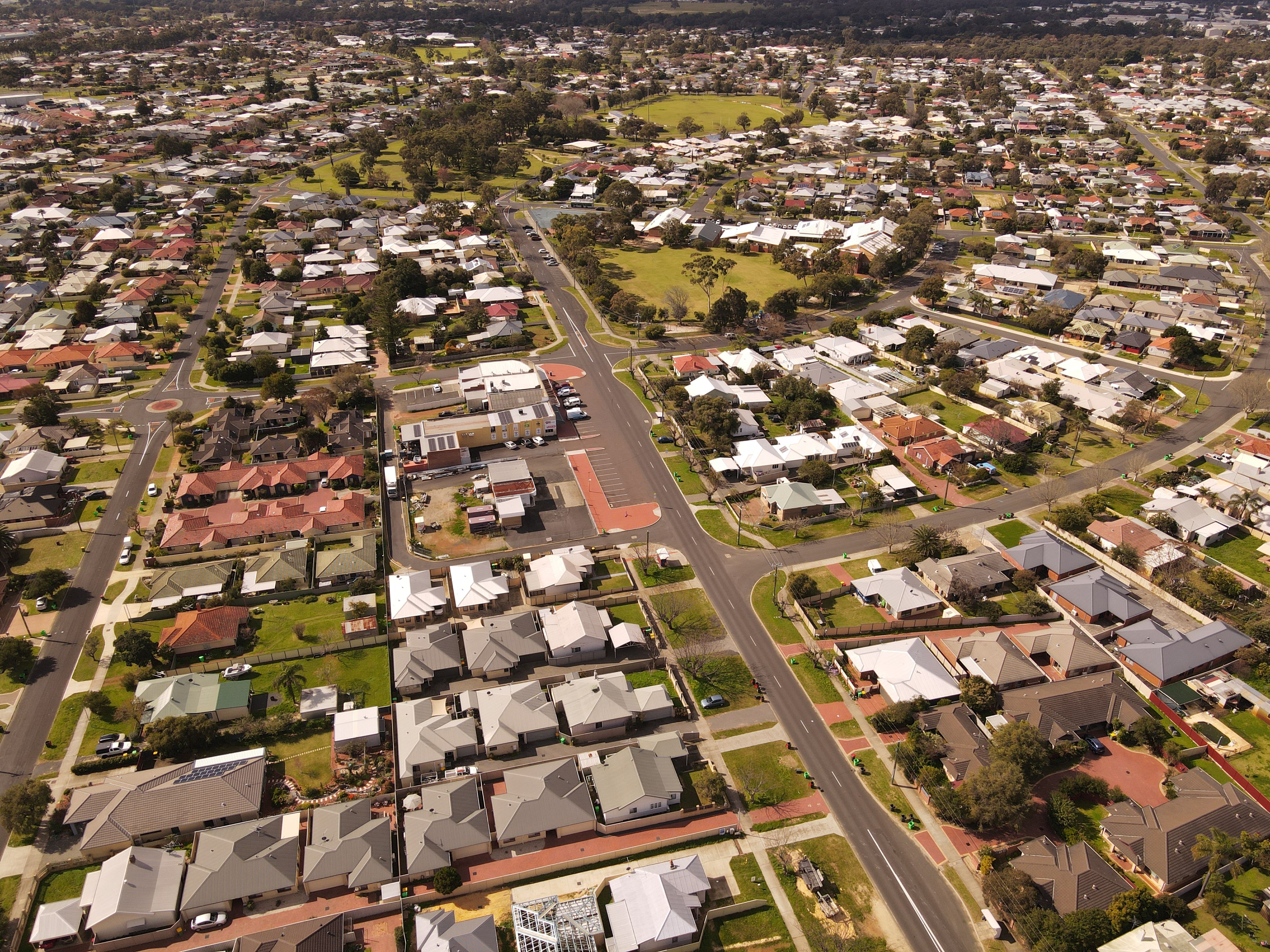 A drone shot of a regional suburb with houses and trees and playgrounds