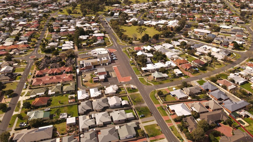 A drone shot of a regional suburb with houses and trees and playgrounds