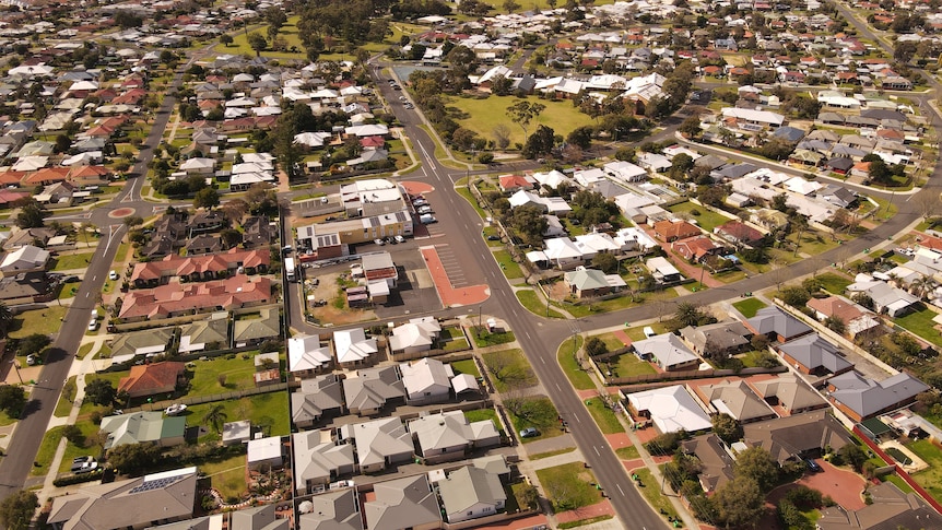 A drone shot of a regional suburb with houses and trees and playgrounds