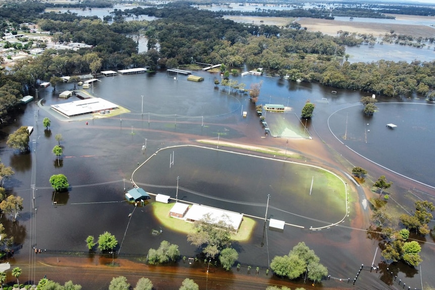 Several large grass arenas and pavilions, inundated by dark brown water.