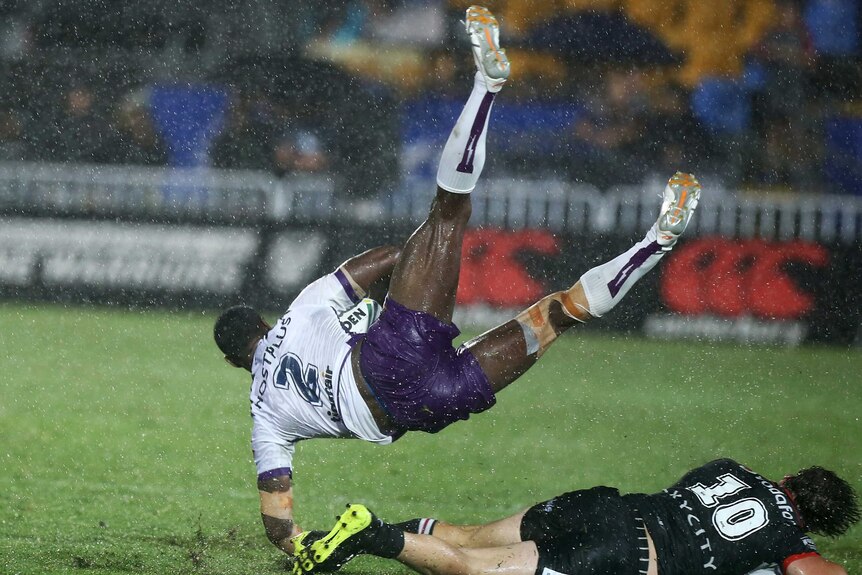 The Storm's Suliasi Vunivalu (L) crashes over Warriors' Charlie Gubb in Auckland on March 10, 2017.