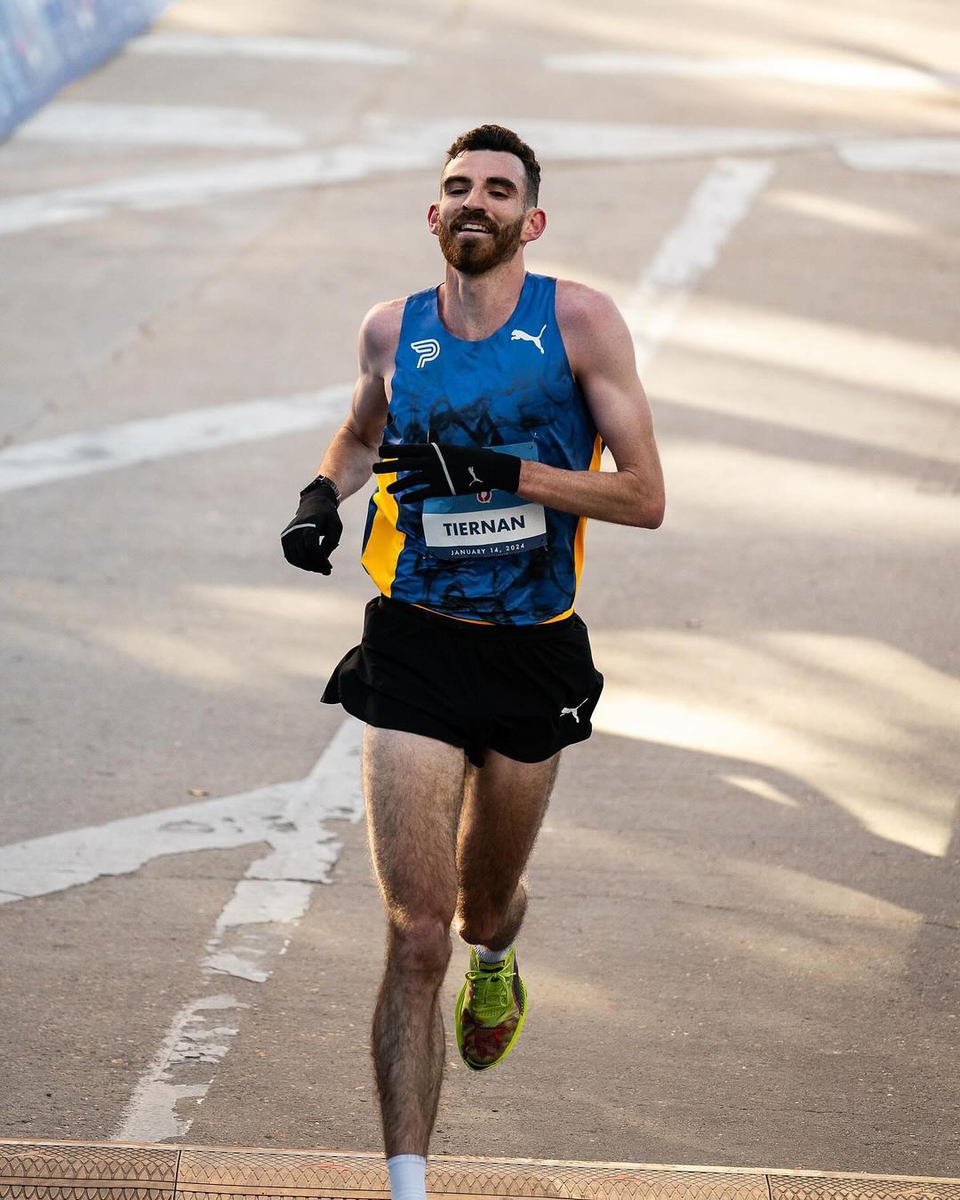 Pat Tiernan smiles as he crosses the finish line of a marathon