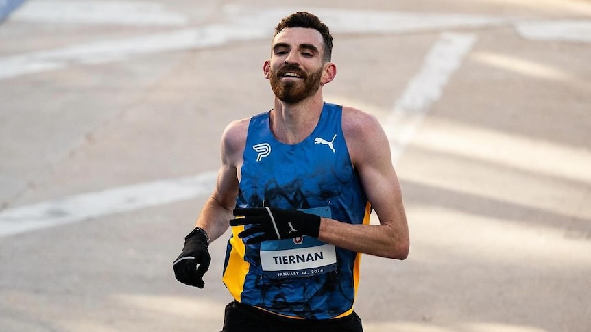 Pat Tiernan smiles as he crosses the finish line of a marathon