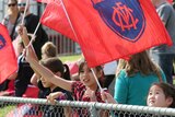 Melbourne fans wave flags at the Round 2 AFLW match between Collingwood and Melbourne at Victoria Park.