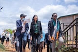 Three people, including Suella Braverman, walk up stairs outside a building in Rwanda