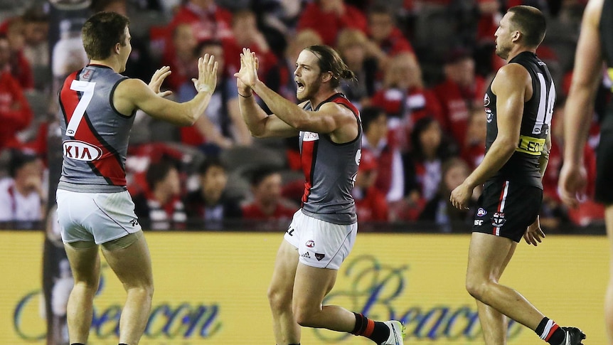 Essendon's Travis Colyer (C) celebrates with Zach Merrett (L) against St Kilda at Docklands.