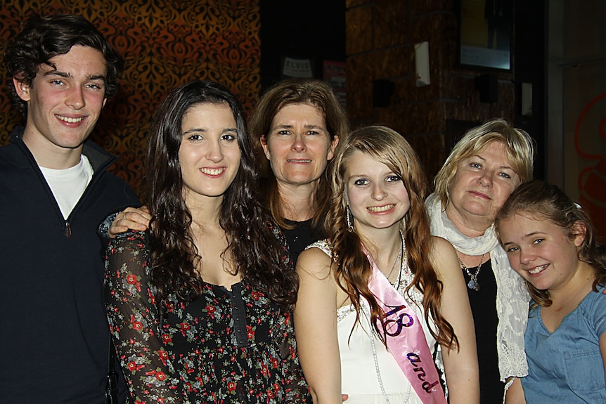 Chris Carr poses with her sister, two nieces and nephew, all dressed up for an 18th birthday party. 