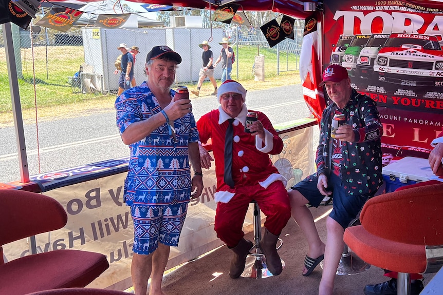 Three men dress in Christmas outfits at the Bathurst 1000