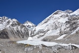 View of tents at Everest base camp with mountains, including Mount Everest (peak in far top right-hand corner), around