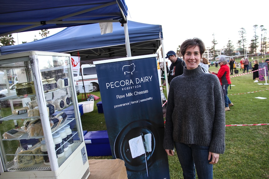 A woman stands in front of her pop up market stall in Kiama