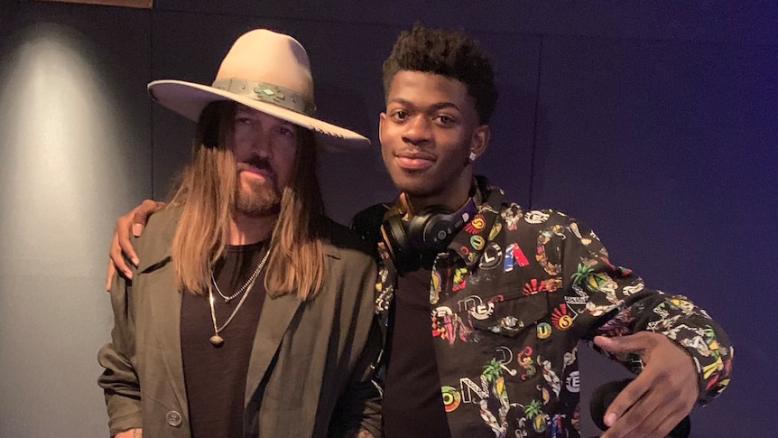 Lil Nas X stands with his arm around country music singer Billy Ray Cyrus.