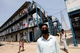 Men wearing face masks stand outside a building in India.