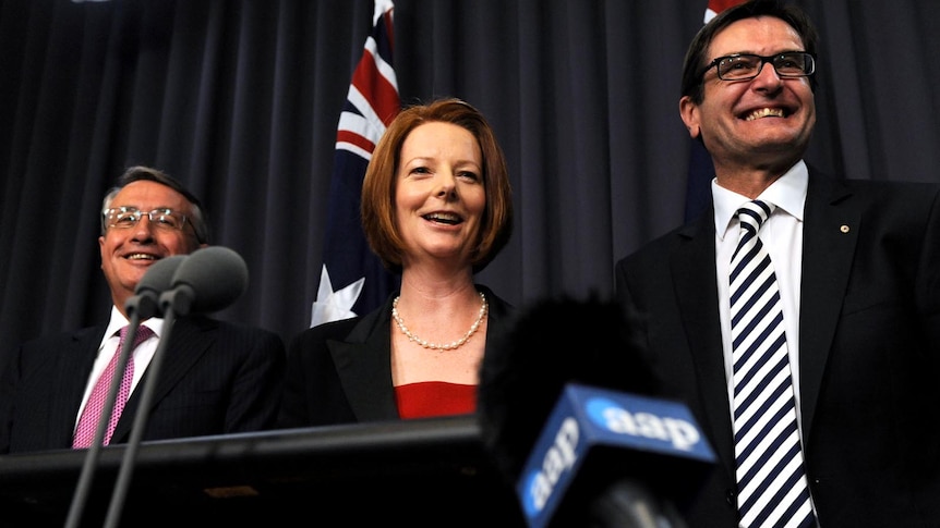 Wayne Swan, Julia Gillard and Greg Combet all smiles after carbon tax legislation is passed.