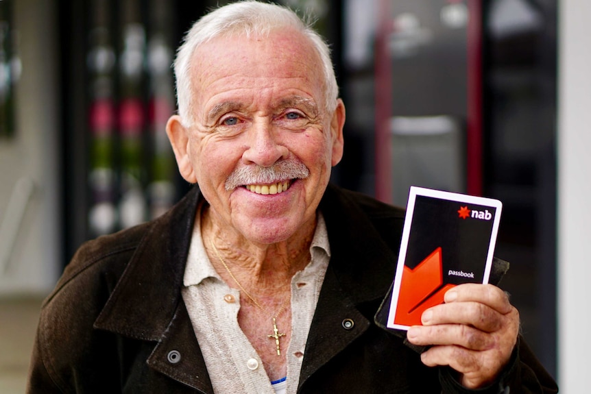 Jim Donaghy standing outside the NAB bank with his pass book