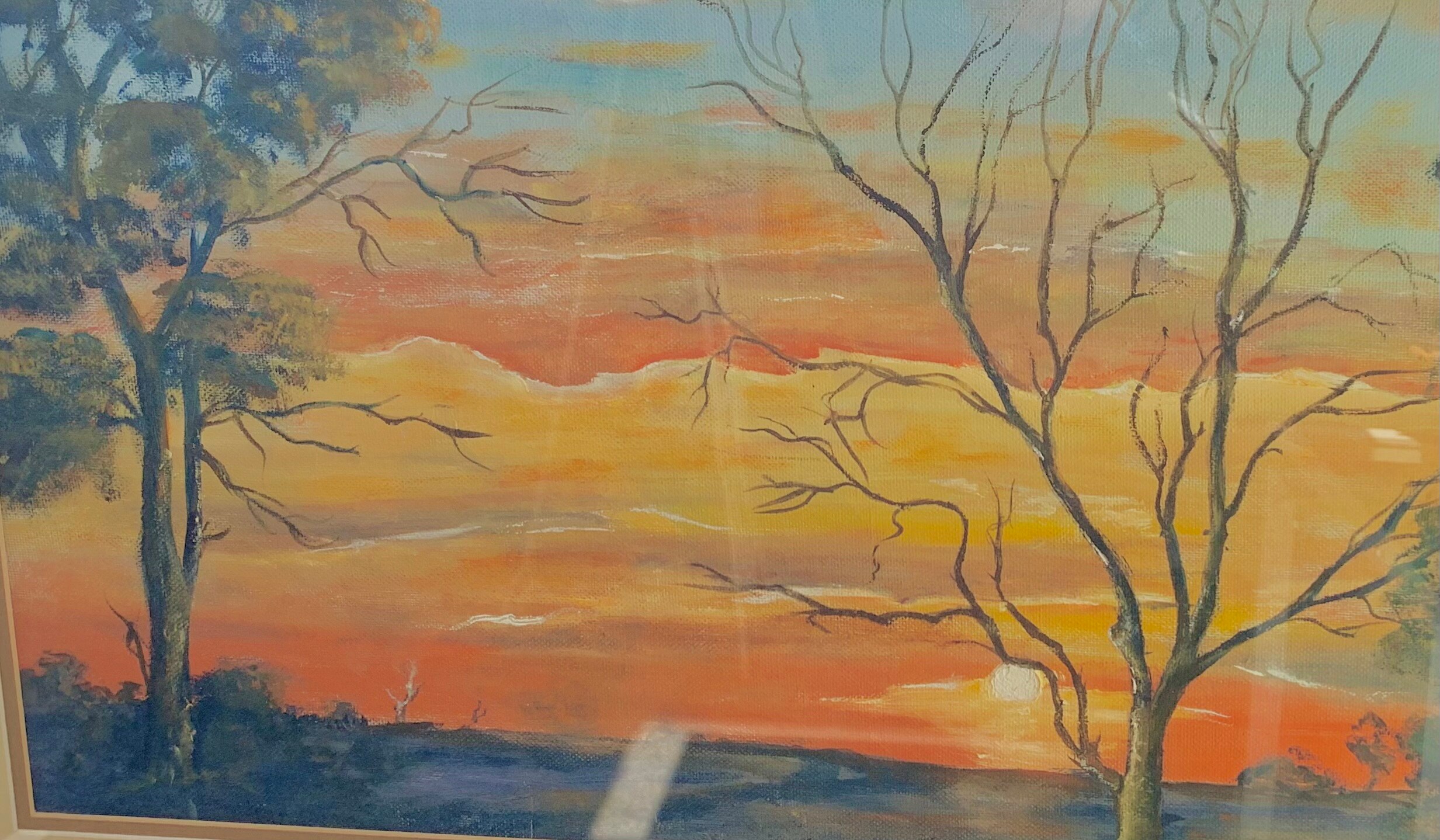 An oil painting of an orange sunset with trees in the foreground