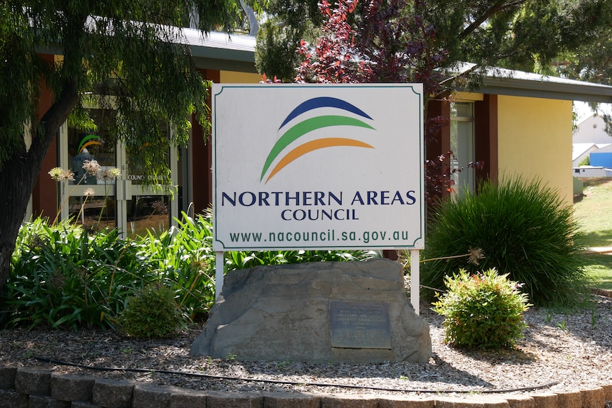 A white sign installed in a garden outside a building reads: Northern Areas Council with a website link. 