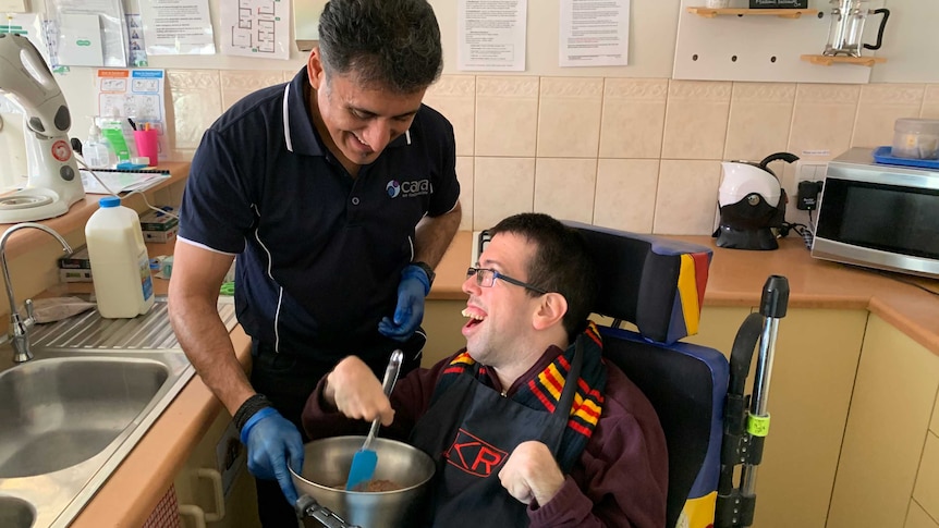 Anton Sagrillo in the kitchen, baking a cake with his support worker, Monish Gambhir