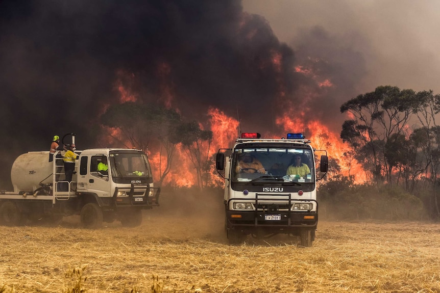 Firefighters in two trucks battle an out of control bushfire at Grass Patch near Esperance.