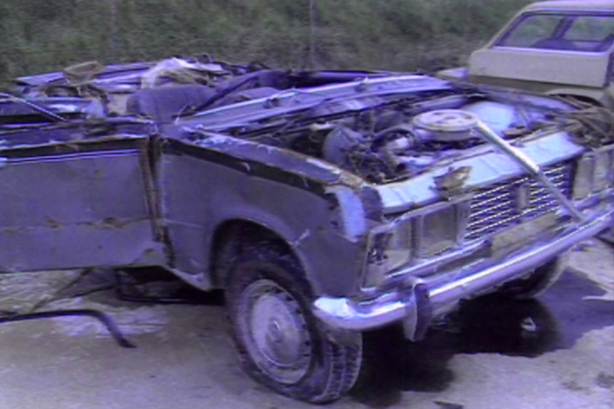 A badly damaged car on a beach