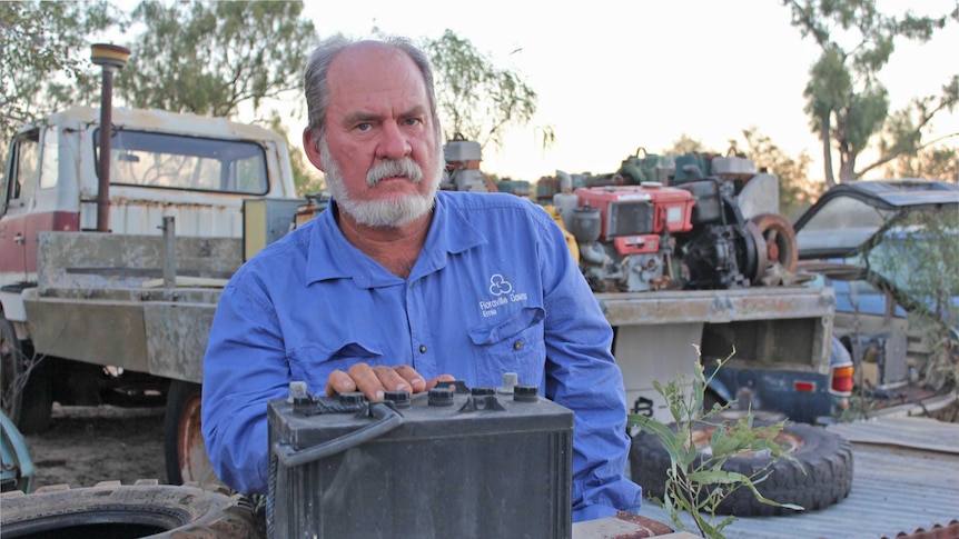 a man stands with a large battery