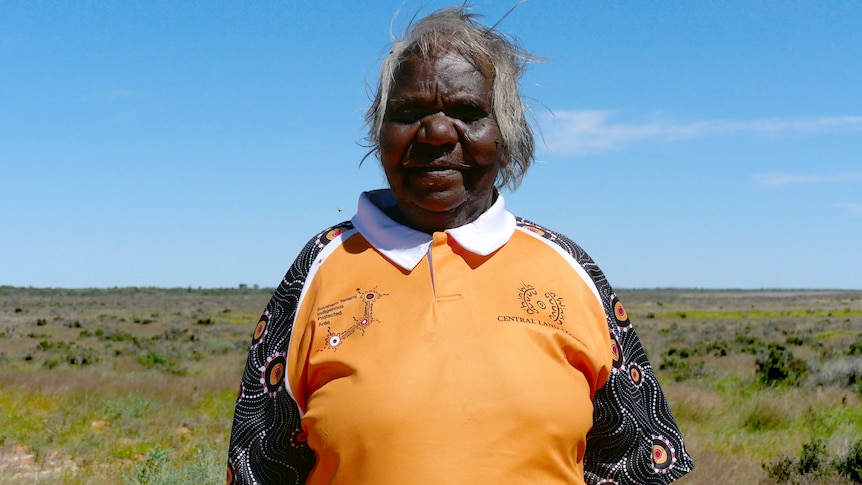 A close up on an Aboriginal woman with short white hair looking at the camera.