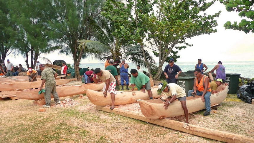 Cook Islands men building traditional wooden canoes by hand