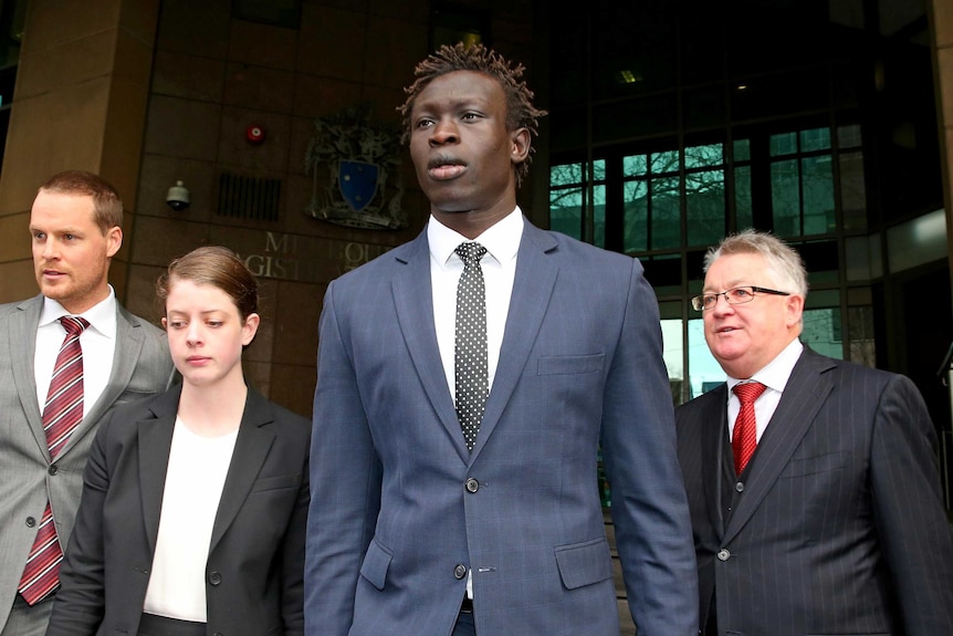 North Melbourne AFL player Majak Daw leaves the Melbourne Magistrates Court.