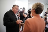 Craig Kelly points at Tanya Plibersek with his mouth wide open. Media are filming the interaction