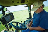 Scientist in a tractor, collecting data on a filed.