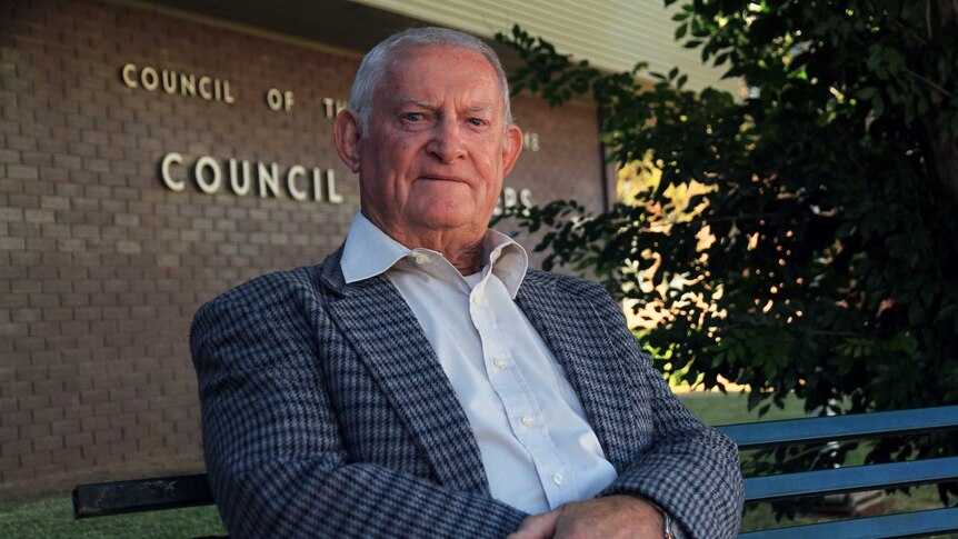 Bourke Shire Council mayor Barry Hollman sits on a park chair outside the council's headquarters.