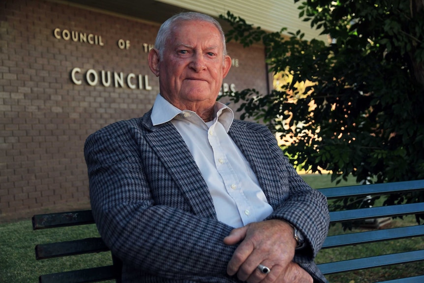Bourke Shire Council mayor Barry Hollman sits on a park chair outside the council's headquarters.
