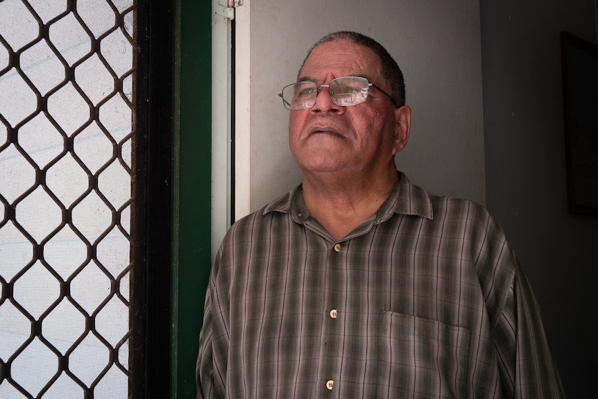 Indigenous man looks out doorway