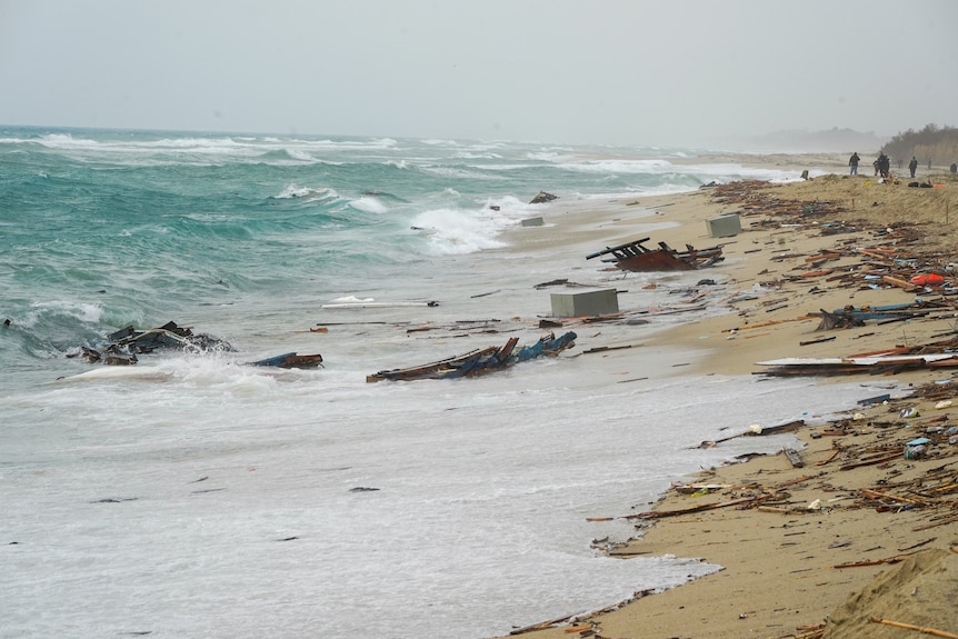 The remains of the boat destroyed by the waves of the stormy sea remain on the beach off Italy.