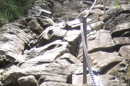 a chain fence leading up rocky terrain