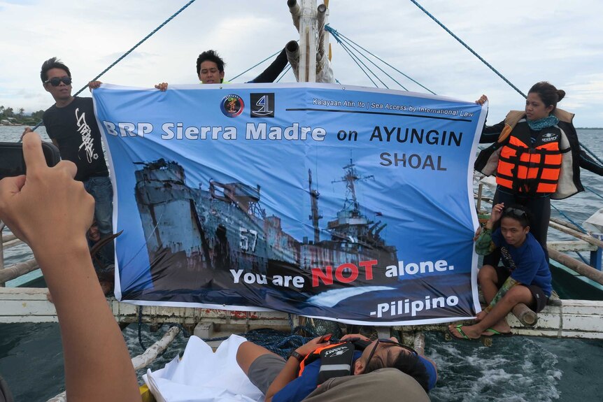Activists from the Filipino organisation Kalayaan Atin Ito unfurl a banner