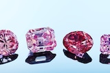 A close up of siix pink, red and violet diamonds in a row