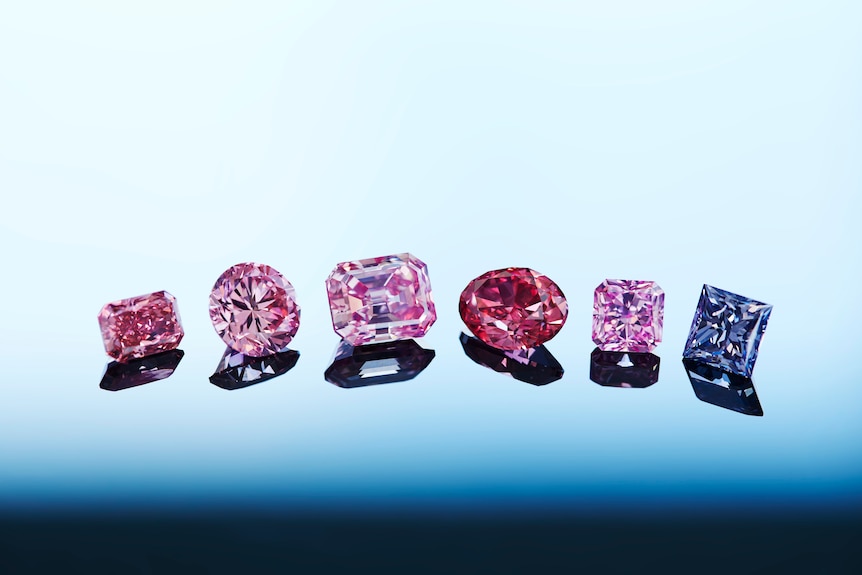 A close up of siix pink, red and violet diamonds in a row