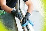 Close up of man wearing gloves cleaning windowsills.