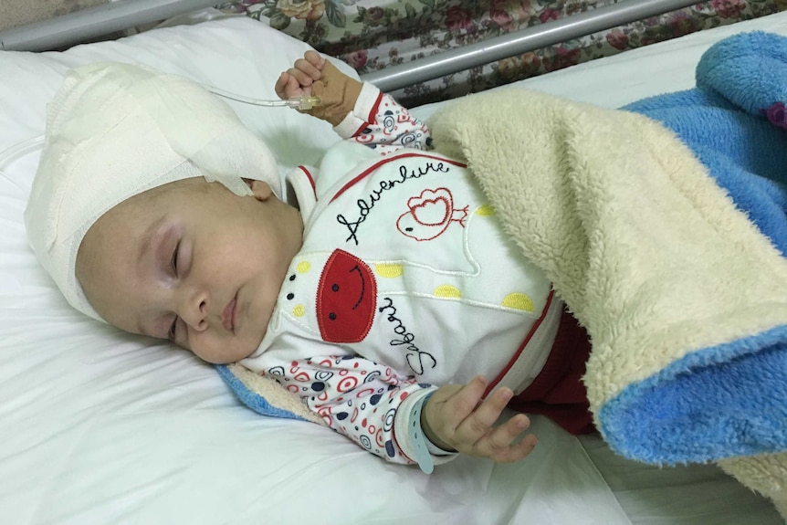 Three-month-old infant Sajid lies in a cot as he receives treatment at the Makassad Hospital in East Jerusalem.
