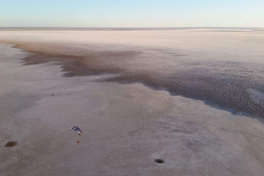 A paraglider can be seen gliding across salt lakes.